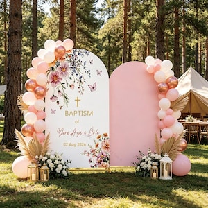 Puede incluir: Un fondo para bautizo con dos paneles arqueados decorados con globos en blanco, rosa y oro rosa metálico. El panel izquierdo muestra ilustraciones florales, mariposas, una cruz dorada y el texto BAPTISM of Yava Aya & Eli le 02 Aug 2026.
