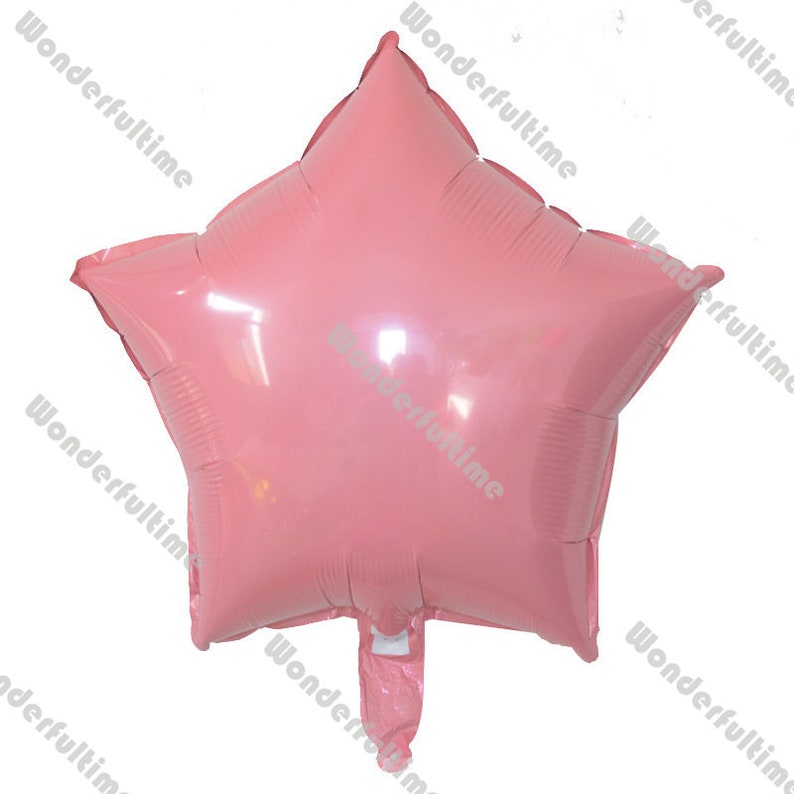 May include: A pink star-shaped foil balloon. The balloon is inflated and ready to be used for a party or celebration.