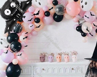 Pode incluir: Um arco de balões de Halloween com balões pretos, brancos, rosa e pêssego. O arco é decorado com morcegos pretos e balões fantasma. Também há alguns balões com padrão de mármore.