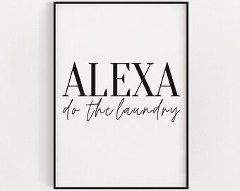 May include: A framed print with the words "ALEXA do the laundry" in black script and sans-serif font on a white background. The print is enclosed in a black frame, suitable for home decor.
