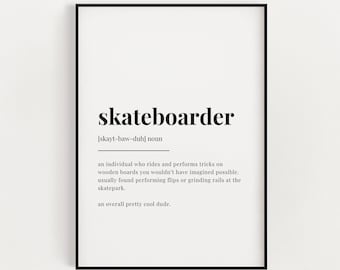 Op de afbeelding: Een ingelijste print met het woord "skateboarder" in zwarte letters. De definitie eronder beschrijft een persoon die trucs uitvoert op houten planken. De print heeft een witte achtergrond en een zwarte lijst.