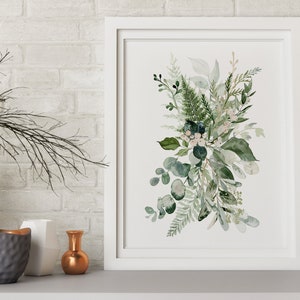 May include: A white framed print featuring a watercolour painting of a bouquet of green leaves and white flowers.