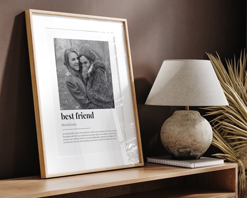 May include: A black and white photo of two friends in a framed print. The print has the word "best friend" and a definition of the word. The definition reads: "An irreplaceable person who makes the world a better place, someone who is by your side throughout all of life's ups and downs, no matter what troubles you face. A person who accepts your weirdness and loves you unconditionally, someone who laughs with you and cries with you. The best thing you can have and the best thing you can be."