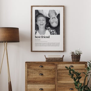 May include: Black and white photo of two friends laughing, printed on a white poster with the text "best friend" and a definition of the word. The poster is framed in a light wood frame.