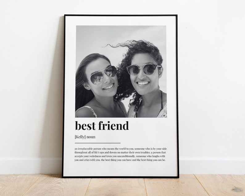 May include: Black and white photo of two friends smiling at the camera. The photo is framed in a black frame and has the text "best friend" and a definition of the word below the photo.