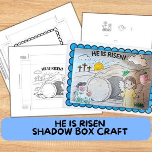 Può includere: Un kit artigianale con la scritta "HE IS RISEN!" include un'illustrazione da colorare della scena della risurrezione, con un angelo, una tomba e delle croci. Il kit include anche modelli per una scatola ombra.