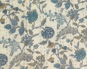 Könnte beinhalten: Eine cremefarbene Steppdecke mit einem Blumenmuster in Blau-, Türkis- und Beigetönen. Die Steppdecke weist ein sich wiederholendes Design aus stilisierten Blumen und Blättern mit sichtbaren Nähten auf. Die Gesamtästhetik ist eine Mischung aus traditionellen und modernen Stilen.