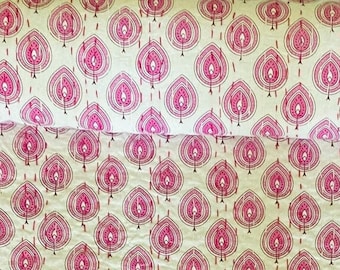 May include: A white cotton quilt with a pink and white floral pattern. The quilt is rolled up and has a white background with pink floral designs.