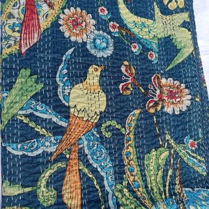 May include: A dark blue quilt with a vibrant bird and floral design. The quilt features colorful birds with orange, yellow, and green feathers, surrounded by flowers and foliage in shades of red, blue, and yellow. White stitching adds texture.