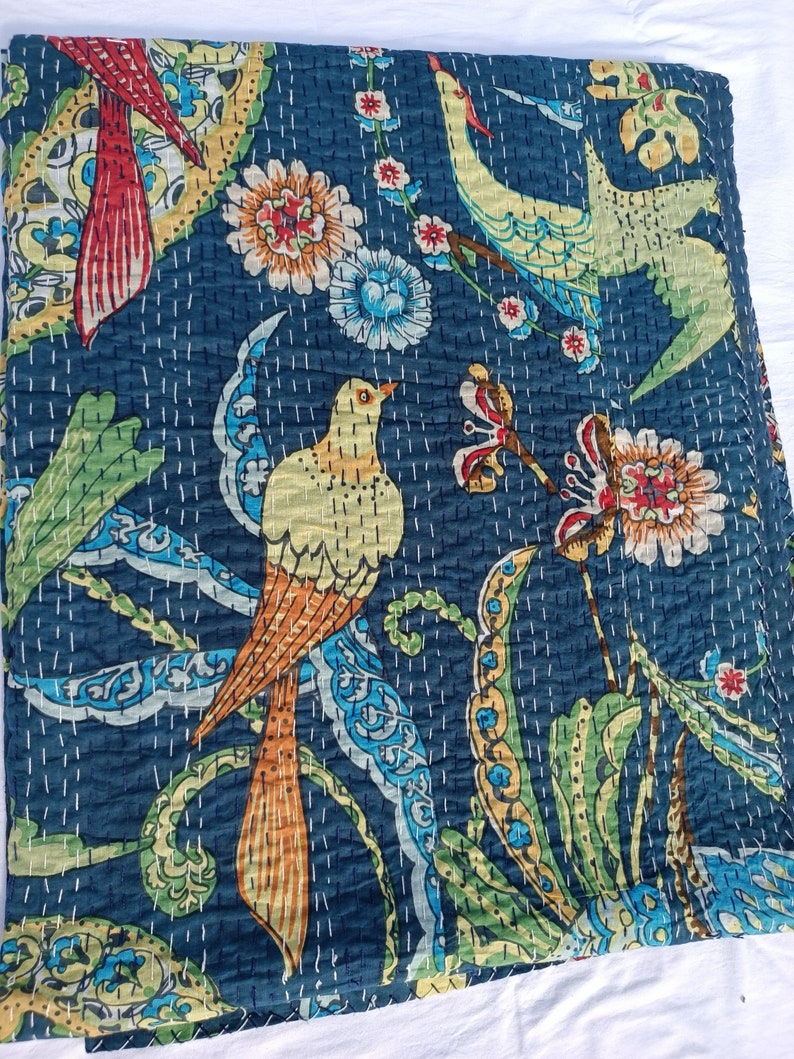 May include: A dark blue quilt with a vibrant bird and floral design. The quilt features colorful birds with orange, yellow, and green feathers, surrounded by flowers and foliage in shades of red, blue, and yellow. White stitching adds texture.
