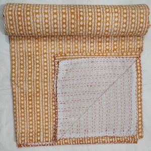 May include: A yellow and white kantha quilt with a geometric pattern. The quilt is folded in half and the stitching is visible on the reverse side.