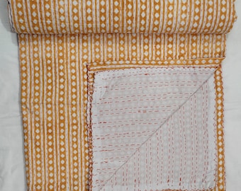 May include: A yellow and white kantha quilt with a geometric pattern. The quilt is folded in half and the stitching is visible on the reverse side.