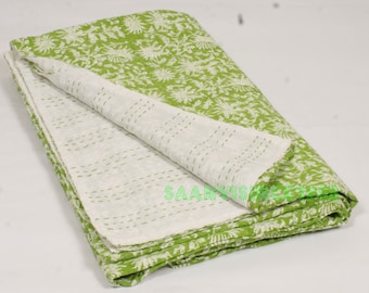 Könnte beinhalten: Eine grüne und weiße Kantha-Steppdecke mit floralem Muster. Die Decke ist in der Hälfte gefaltet und die Nähte sind sichtbar.