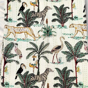 Può includere: Tessuto di cotone bianco con un motivo ripetitivo di zebre, tucani, leopardi, fenicotteri e palme. Il tessuto ha una texture trapuntata.