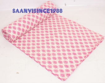 May include: A rolled-up fabric with a repeating pink and white pattern. The pattern consists of pink teardrop shapes with a white center, arranged in a grid. The text "SAANVISINCE1988" is visible in the upper left corner.