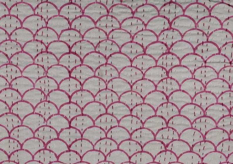 May include: White fabric with a repeating pattern of pink, semi-circular shapes, resembling a scale design. The design is stitched with pink thread, creating a textured surface. The overall aesthetic is simple and elegant.
