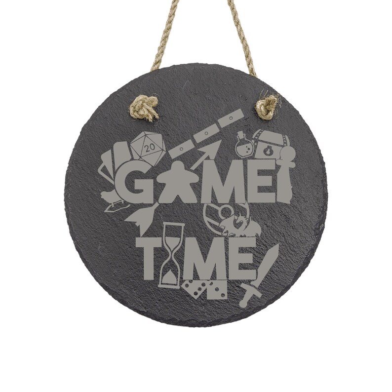 Peut inclure: Une pancarte ronde en ardoise noire avec un cintre en corde. La pancarte indique "Game Time" avec diverses ic&ocirc;nes li&eacute;es aux jeux, notamment un d&eacute;, une pi&egrave;ce de jeu, une &eacute;p&eacute;e et un sablier.