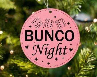 May include: Pink Christmas bauble with the text "BUNC0 Night" and three dice with black dots.