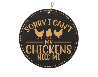 May include: Black leather ornament with gold stitching and the text "Sorry I can't my chickens need me". Three gold chicken silhouettes are above the text.