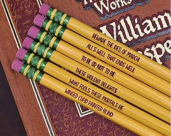 May include: Set of six yellow pencils with green and red accents. Each pencil is inscribed with a famous Shakespeare quote: "Beware the Ides of March", "All's well that ends well", "To be or not to be", "These violent delights", "What fools these mortals be", and "Winged Cupid painted blind".