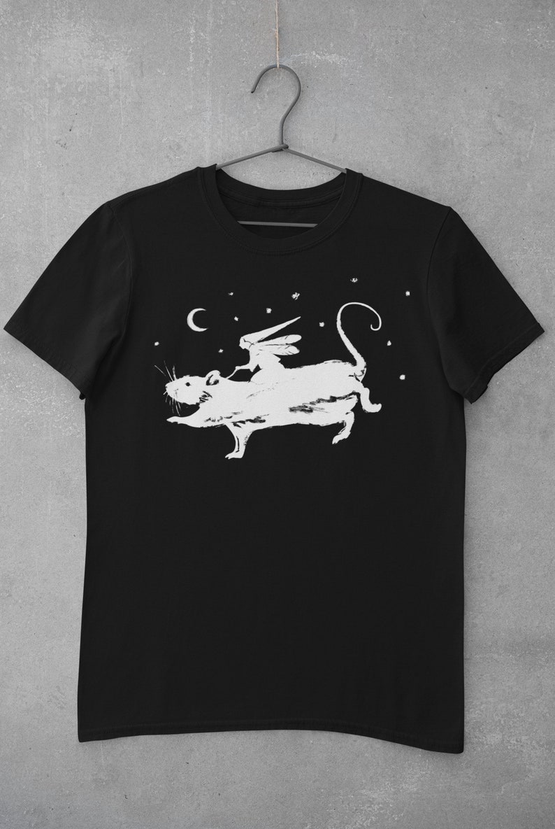 Puede incluir: Camiseta negra con un gr&aacute;fico blanco de una hada montando una rata bajo una luna creciente y estrellas.