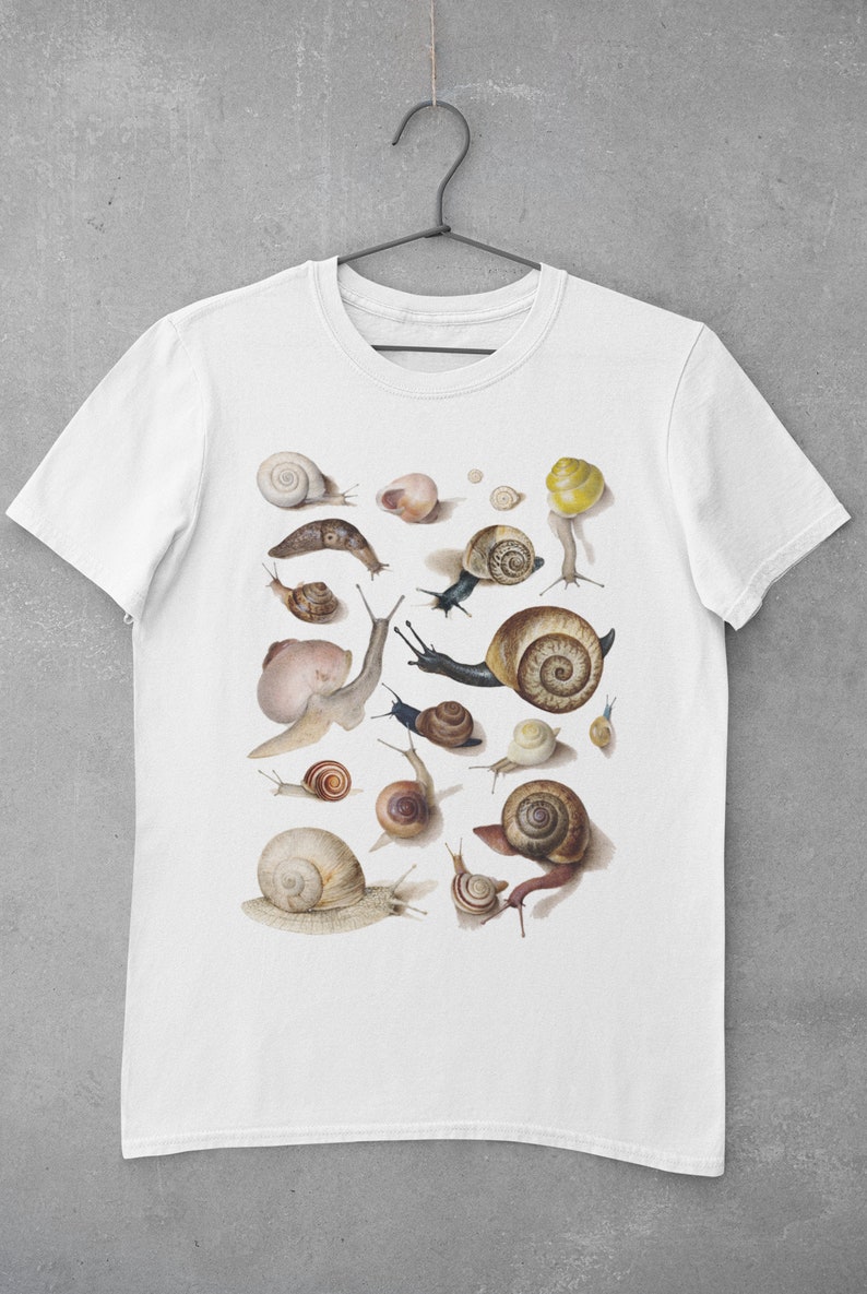 May include: White t-shirt with a print of various snails in different sizes and colors. The snails are arranged in a random pattern on the shirt.