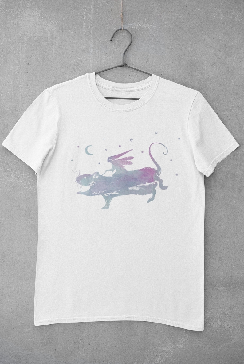 Puede incluir: Camiseta blanca con una ilustraci&oacute;n de acuarela de una hada montando una rata en un cielo estrellado.