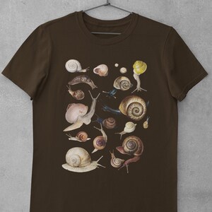 May include: A brown t-shirt with a print of various snails in different sizes and colors. The snails are arranged in a random pattern on the shirt.