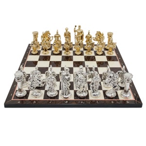 Op de afbeelding: Een schaakset met gouden en zilveren stukken op een houten bord. De stukken zijn in de vorm van Romeinse soldaten en andere figuren. Het bord heeft een zwart-wit geblokt patroon.