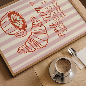 Framed coffee print resting near books and a warm coffee mug, ideal for a cozy aesthetic.