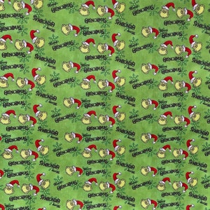 Puede incluir: Tela verde con un patr&oacute;n repetido del Grinch con gorro de Pap&aacute; Noel, copos de nieve y las palabras "Merry Grinchmas". El Grinch es amarillo y el gorro es rojo. El texto es negro.