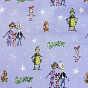 Puede incluir: Una tela de color lila claro con personajes de dibujos animados y estrellas blancas. Se representan el Grinch, Cindy Lou Who, Max el perro y otros personajes. La palabra "GRINCH" est&aacute; escrita en verde. Esta tela es adecuada para varios proyectos de manualidades.