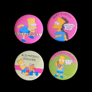 May include: Four round, colorful buttons featuring cartoon images of Bart Simpson from the animated television show The Simpsons. The buttons feature different quotes from the show, including "Aye Carumba!" and "Don't have a cow, man!"