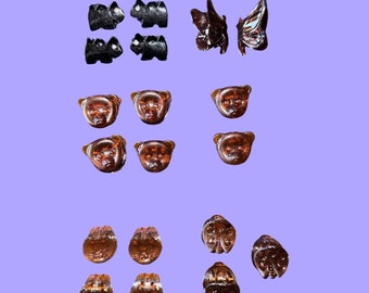 May include: Assortment of brown and black resin hair clips. The clips feature bear, butterfly, and ladybug designs.