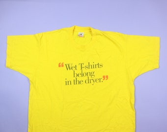 Könnte beinhalten: Gelbes T-Shirt mit dem Aufdruck "Wet T-shirts belong in the dryer." in Schwarz.