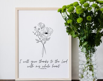 Könnte beinhalten: Ein gerahmter Kunstdruck mit einem minimalistischen Blumendesign in schwarzer Tinte. Der Druck enthält den Text "Ich will dir danken, Herr, von ganzem Herzen" aus Psalm 86,1. Rechts vom Druck steht eine Vase mit grünen Blumen.