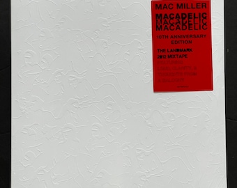 Può includere: Un disco in vinile bianco con un adesivo quadrato rosso nell'angolo in alto a destra. L'adesivo dice "Mac Miller Macadelic Macadelic Macadelic 10th Anniversary Edition The Landmark 2012 Mixtape Featuring Larry Hardy & Thundercat from a Balcony".