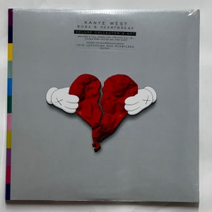 Op de afbeelding: Een grijze vinyl platenhoes met een afbeelding van een gebroken rode hartballon. De tekst op de hoes luidt "Kanye West 808s & Heartbreak Deluxe Collector's Set Includes 2 Full Length Vinyl LPs Plus Full CD, Double-Sided Poster and Lyric Sheet Features the Groundbreaking Singles Love Lockdown and Heartless".
