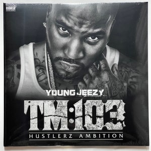May include: Black and white album cover featuring a close-up portrait of rapper Young Jeezy. The album title "TM:103 Hustlerz Ambition" is printed in bold white letters on a black background.