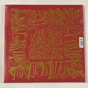 May include: A red vinyl record album with gold lettering and illustrations. The album cover features ornate script with song titles and the words "My Beautiful Dark Twisted Fantasy". The record is sealed in plastic.
