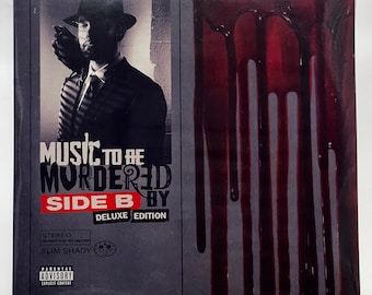 May include: A vinyl record album titled "Music to Be Murdered By: Side B Deluxe Edition." The album cover features a black and white image of a man in a suit and hat, with red streaks resembling blood. The album is sealed in plastic.