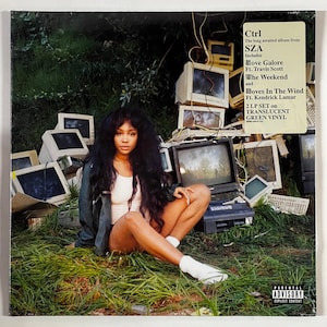 May include: A green vinyl record album cover featuring a woman sitting in a pile of old computers. The album is titled "Ctrl" and is by the artist SZA. The album includes the songs "Love Galore" featuring Travis Scott, "The Weekend", and "Doves In The Wind" featuring Kendrick Lamar.