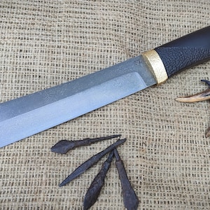 The knife is made of Viking arrowheads.Viking knife "Seax" from 1000 year old arrowheads.