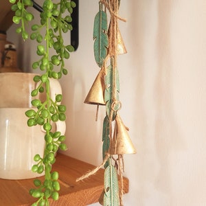 Campanelli eolici sospesi con campanacci da mucca su una corda con pendenti in ottone patinato verde, campanelli da strega, appendiabiti da porta rustico vintage, acchiappasole