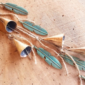 Hanging windchime with cow bells on a string with green patina brass feather pendants, witch bells, rustic vintage door hanger, suncatcher