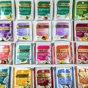 May include: A collection of 20 different Twinings tea bags, each with a unique blend and flavor. The tea bags are arranged in a grid pattern, with each bag featuring a different color and design. The tea bags are all labeled with the Twinings logo and the name of the blend.