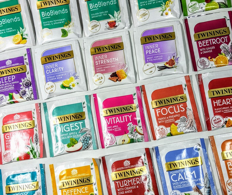 May include: A collection of 16 different Twinings tea boxes with various flavors, including Sleep, Inner Clarity, Inner Strength, Inner Peace, Beetroot with Ginger & Orange, Digest, Vitality, Focus, Heart, Defence, Turmeric with Orange & Star Anise, Moment of Calm, and Glow. The boxes are arranged in a grid pattern on a white surface.