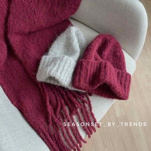 May include: Two knitted hats, one burgundy and one light gray, with a burgundy scarf with long fringe. The text "SEASONSET_BY_TRENDS" is visible in the image.