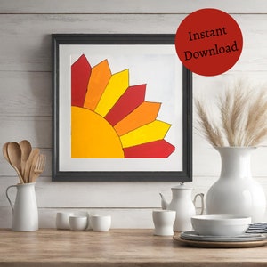 May include: A framed print of a colorful sunburst design with red, orange, and yellow colors. The sunburst is in the corner of the frame and is set against a white background.