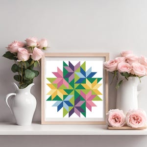 May include: A framed print of a colorful geometric design with a starburst pattern in shades of pink, yellow, blue, green, and purple.